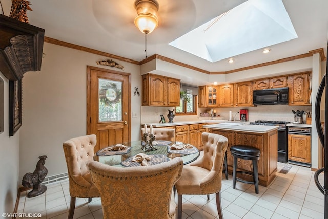 kitchen with black microwave, a kitchen island, light countertops, a kitchen bar, and stainless steel range with gas stovetop