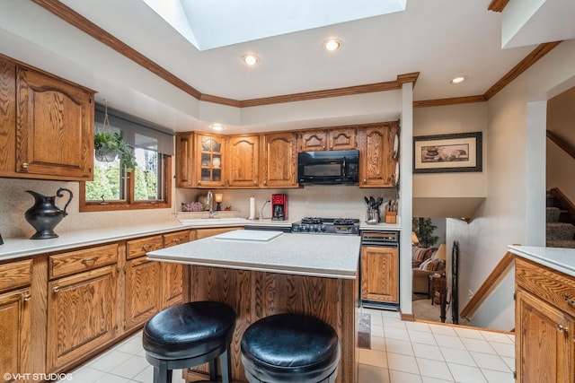 kitchen featuring a kitchen island, brown cabinets, light countertops, crown molding, and black microwave