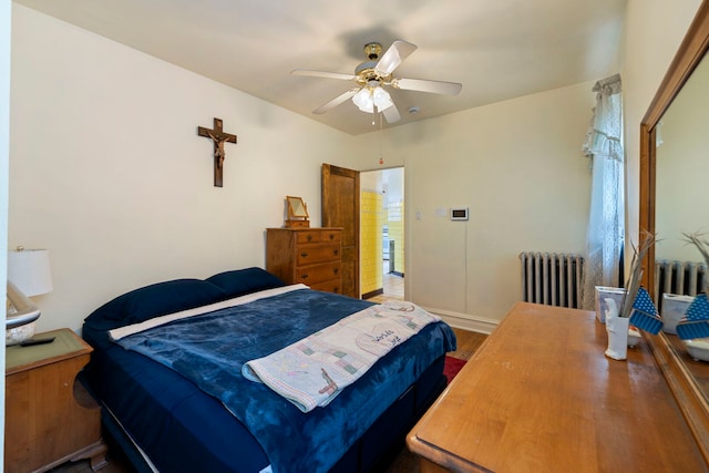 bedroom with ceiling fan, radiator heating unit, and wood finished floors