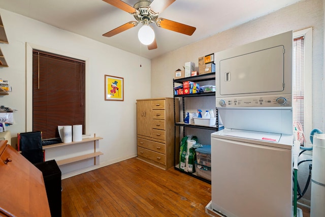 office with stacked washer and dryer, a ceiling fan, and hardwood / wood-style flooring