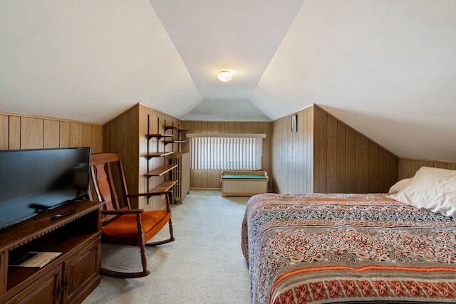 bedroom with lofted ceiling, wood walls, and light carpet