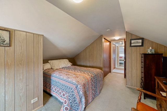 carpeted bedroom with wooden walls and vaulted ceiling