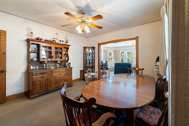 dining area featuring light carpet, baseboards, and a ceiling fan