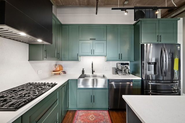 kitchen with green cabinetry, custom range hood, stainless steel appliances, and a sink