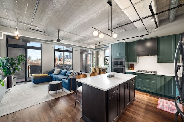 kitchen featuring a view of city, decorative light fixtures, light countertops, wood finished floors, and green cabinetry