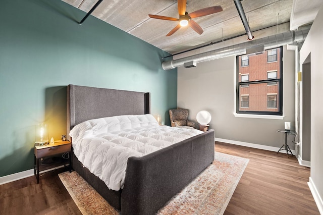 bedroom with wood finished floors, a ceiling fan, and baseboards