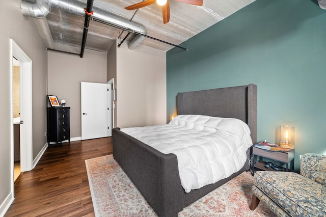 bedroom featuring baseboards and dark wood-type flooring