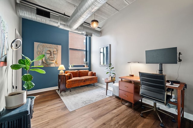 office area featuring visible vents, baseboards, and wood finished floors