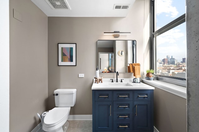 bathroom featuring toilet, tile patterned floors, visible vents, and a city view