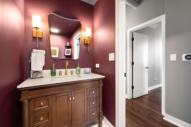 bathroom with wood finished floors, vanity, and baseboards