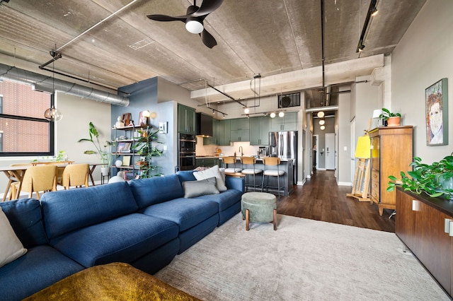 living area with rail lighting, ceiling fan, and dark wood-style flooring