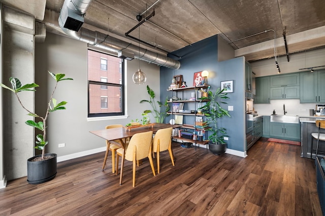 dining space with track lighting, baseboards, and dark wood-type flooring