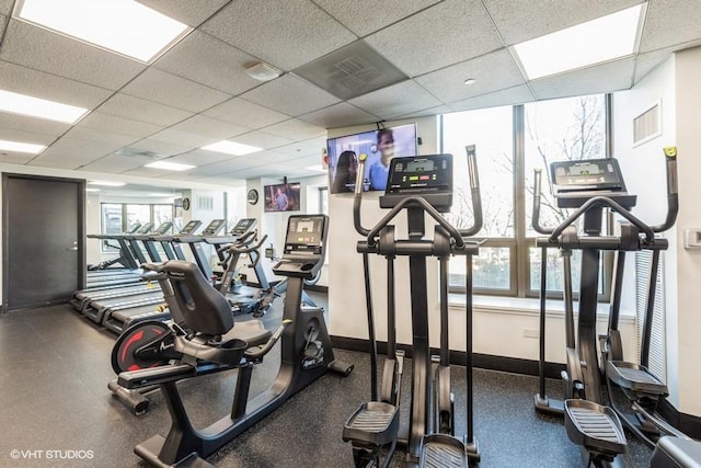 workout area with a paneled ceiling, visible vents, and baseboards