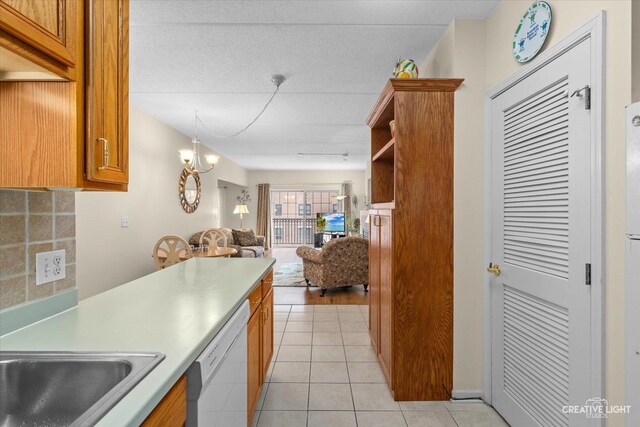 420 W Burlington Ave Unit 303, La Grange, IL 60525 - kitchen featuring dishwasher, open floor plan, brown cabinetry, and light tile patterned floors