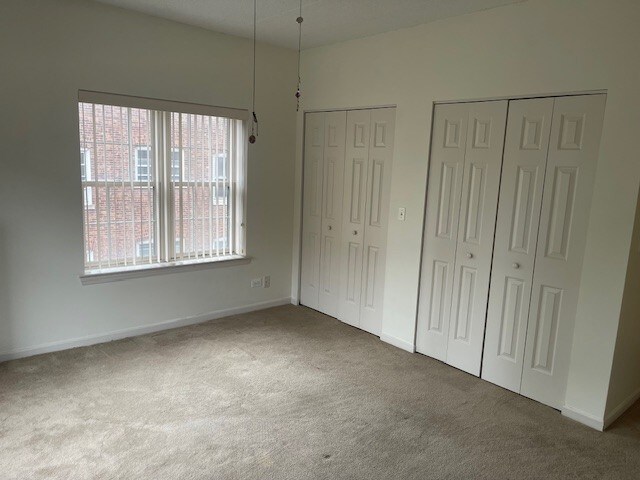 420 W Burlington Ave Unit 303, La Grange, IL 60525 - unfurnished bedroom with carpet flooring, two closets, and baseboards