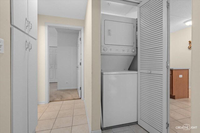 420 W Burlington Ave Unit 303, La Grange, IL 60525 - laundry room featuring estacked washer and dryer, light tile patterned floors, and baseboards
