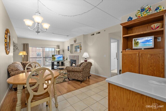 420 W Burlington Ave Unit 303, La Grange, IL 60525 - dining space featuring a chandelier, a tile fireplace, light tile patterned floors, and baseboards