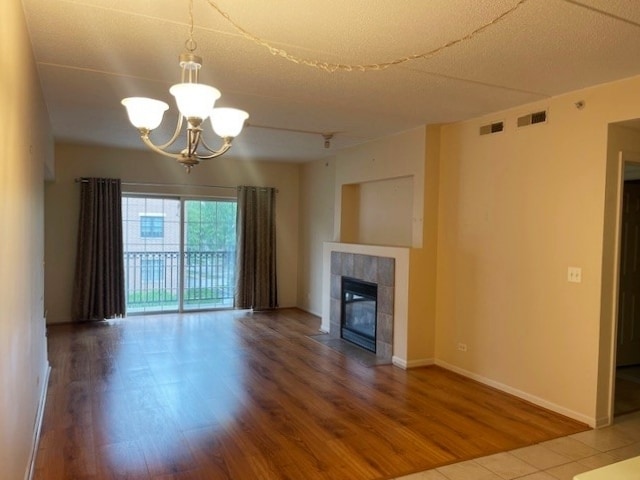 420 W Burlington Ave Unit 303, La Grange, IL 60525 - unfurnished living room with wood finished floors, a chandelier, a fireplace, and baseboards