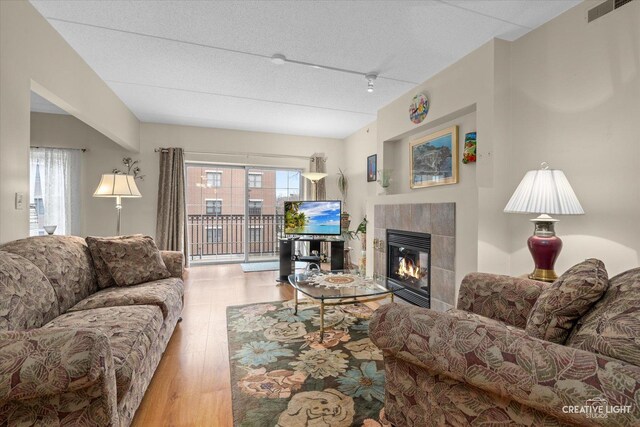 420 W Burlington Ave Unit 303, La Grange, IL 60525 - living area with a fireplace, wood finished floors, and a textured ceiling