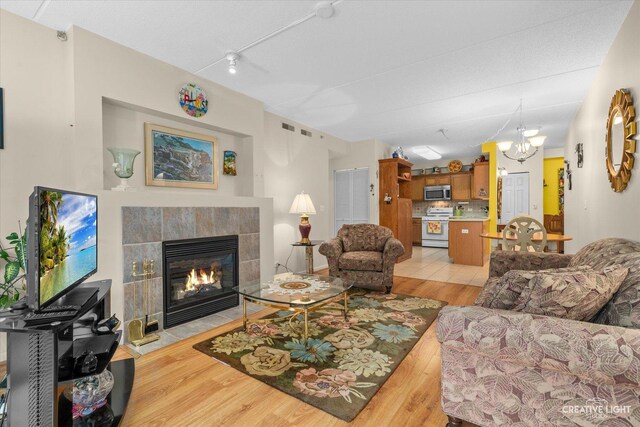 420 W Burlington Ave Unit 303, La Grange, IL 60525 - living area with a tile fireplace, light wood-style flooring, and a chandelier