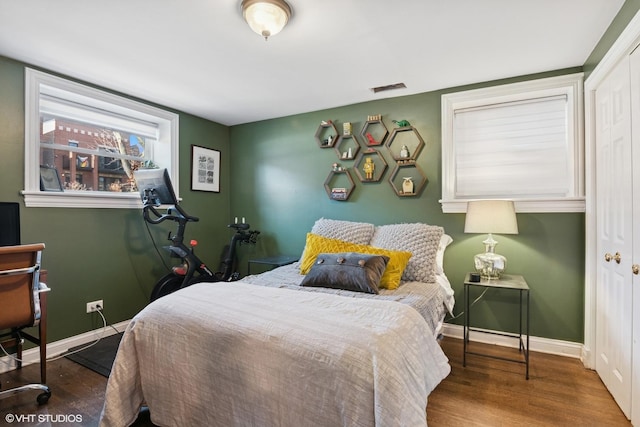 bedroom featuring a closet, baseboards, and wood finished floors