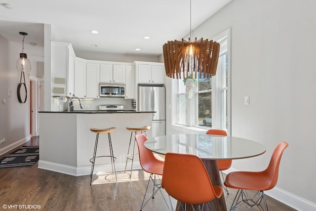 kitchen with plenty of natural light, appliances with stainless steel finishes, white cabinetry, and dark wood-type flooring