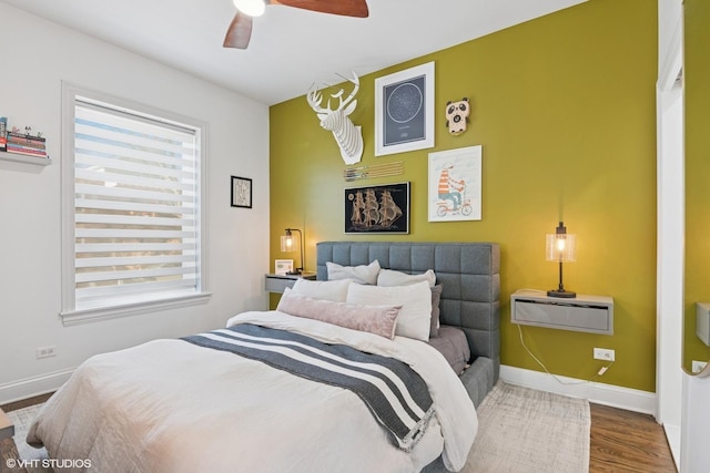 bedroom with ceiling fan, baseboards, and wood finished floors