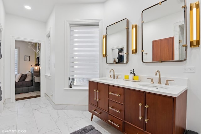 bathroom with double vanity, recessed lighting, marble finish floor, and a sink