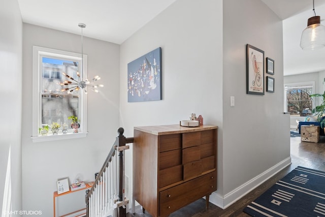 interior space featuring dark wood finished floors, an inviting chandelier, an upstairs landing, and baseboards