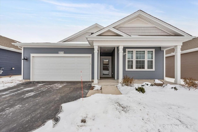 view of front of property featuring an attached garage and aphalt driveway