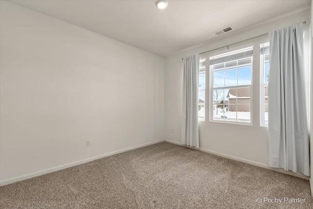 carpeted empty room featuring visible vents and baseboards