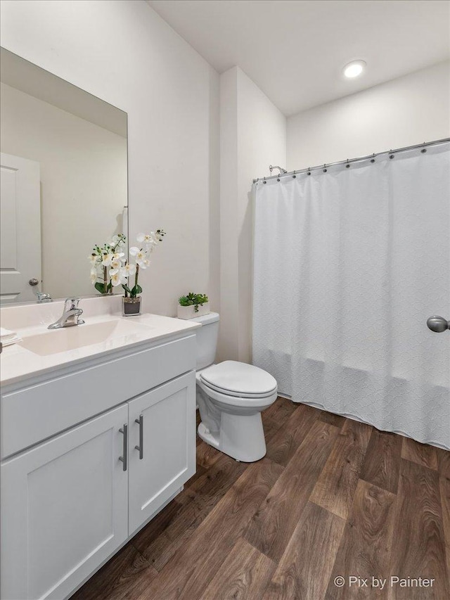 full bath with shower / bathtub combination with curtain, vanity, toilet, and wood finished floors