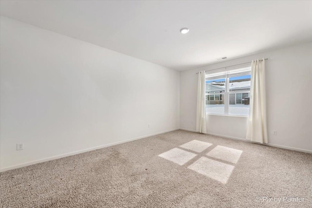 unfurnished room featuring light colored carpet and baseboards