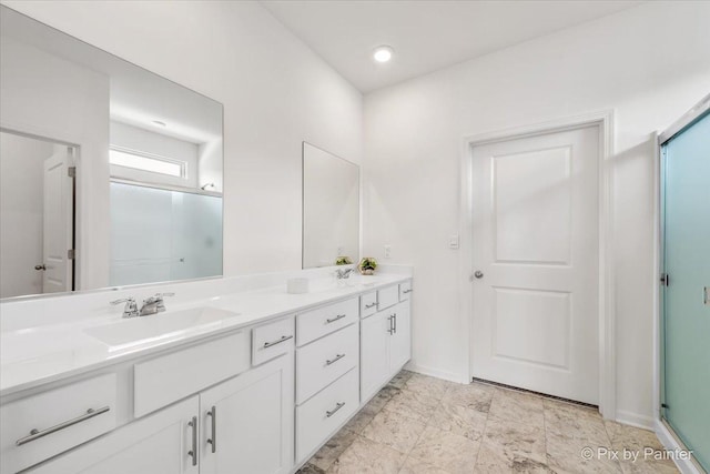 bathroom with a sink, a shower stall, baseboards, and double vanity