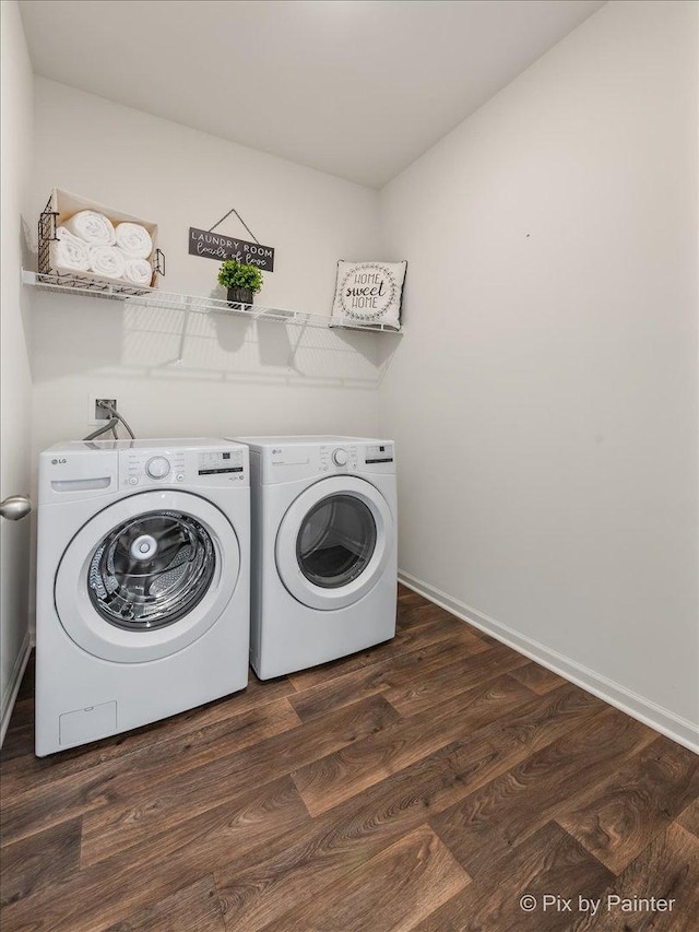 laundry area with laundry area, baseboards, dark wood finished floors, and washer and dryer