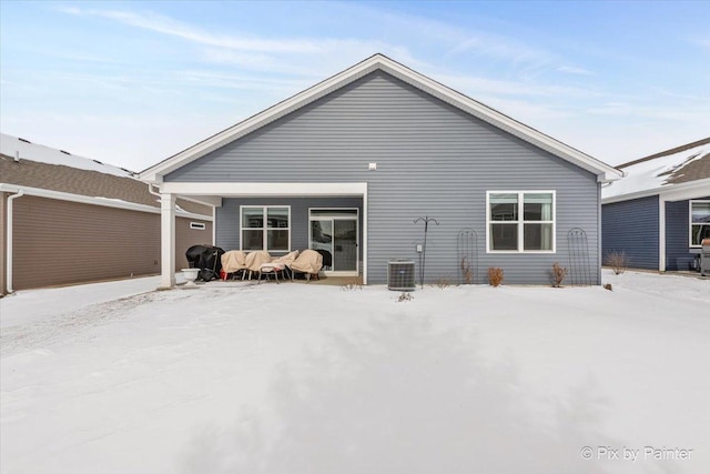 snow covered house with central AC unit