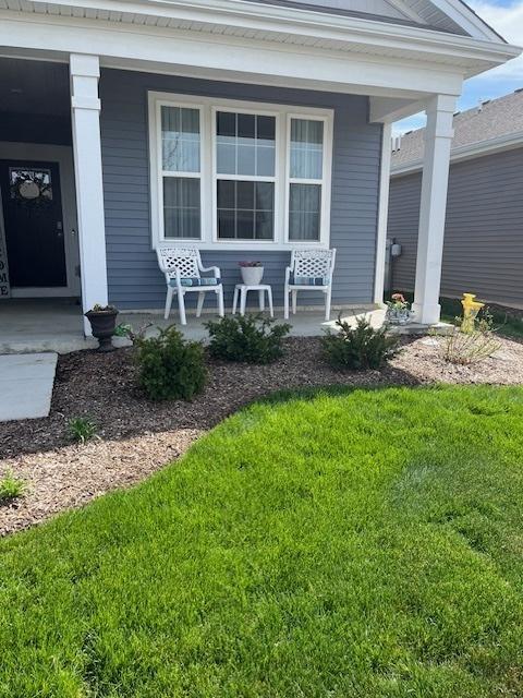 property entrance featuring a porch and a yard