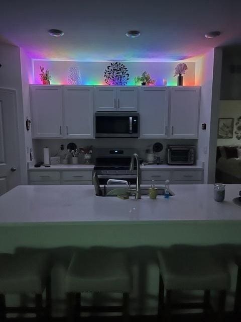 kitchen with white cabinetry, stainless steel appliances, and light countertops