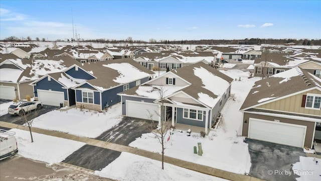 snowy aerial view with a residential view