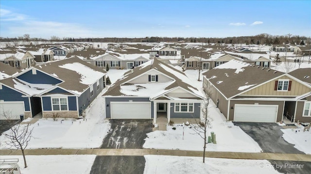 snowy aerial view with a residential view