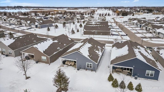 snowy aerial view with a residential view