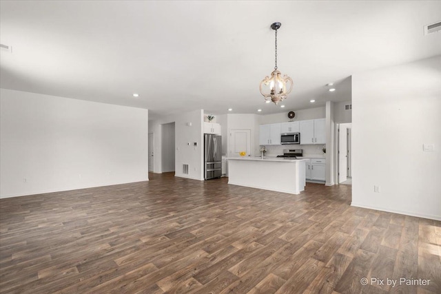 unfurnished living room featuring dark wood-style floors, visible vents, a notable chandelier, and recessed lighting