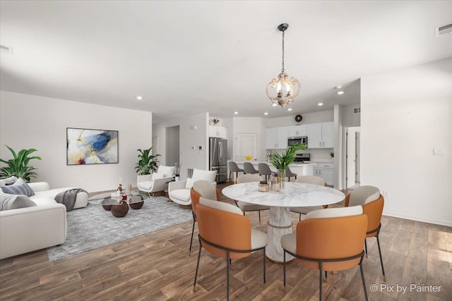 dining space with recessed lighting, wood finished floors, visible vents, and a notable chandelier