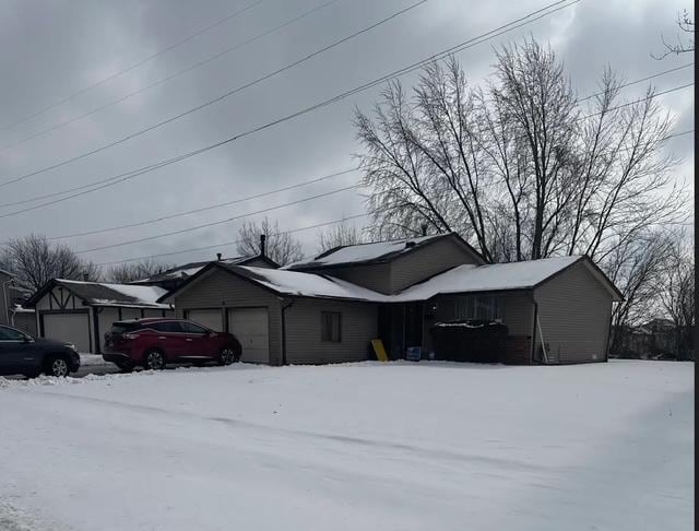 snow covered property with a garage