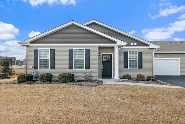 view of front of property featuring driveway, a garage, and a front yard