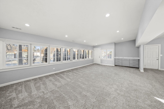 unfurnished living room with recessed lighting, baseboards, visible vents, and carpet flooring