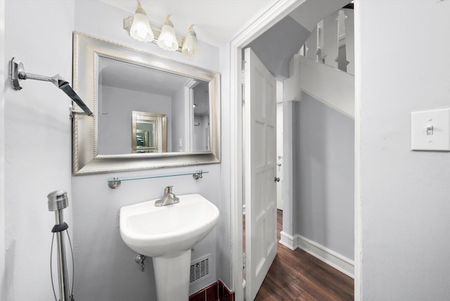 bathroom with a sink, baseboards, and wood finished floors