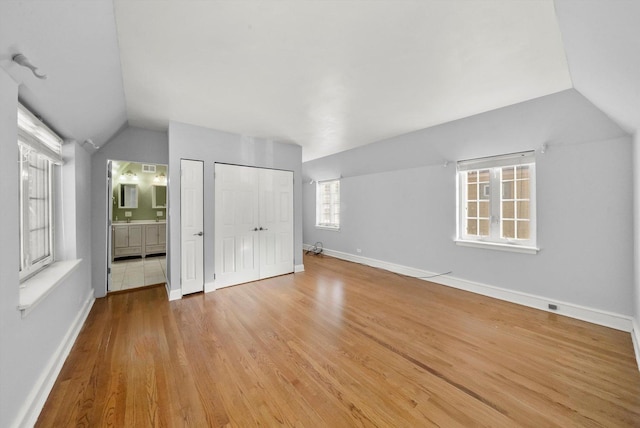 bonus room with lofted ceiling, light wood-style flooring, and baseboards