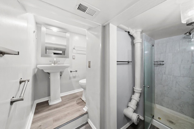 full bath featuring a stall shower, baseboards, visible vents, toilet, and wood finished floors