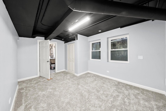 finished below grade area with light colored carpet and baseboards